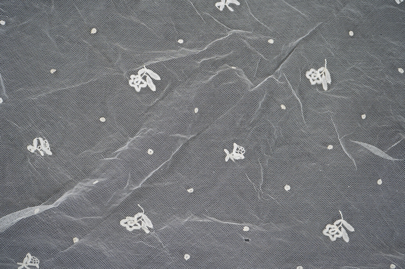 A late Edwardian hand bobbin lace Honiton and net wedding veil, approximately 248cm x 230cm. Condition - one corner has corner has been attached to a hair comb and damaged the netting.